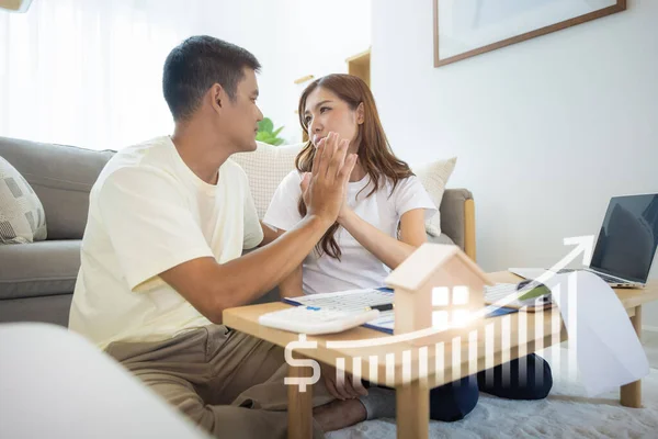 Stock image Asian couple in home or house. Include increasing graph, laptop, calculator and document on table. Concept for marriage, family, house value, market price, loan, finance, real estate and property.