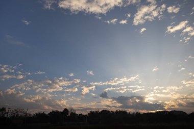 Gökyüzü çok güzel ve bulutlu. Manzara uzay, doğanın ışığı, gün batımı, gün doğumu, ufuk çizgisi veya ufuk çizgisi içerir. Sonbaharda arka plan ve duvar kağıtları için sarı, turuncu ve mavi renkte..