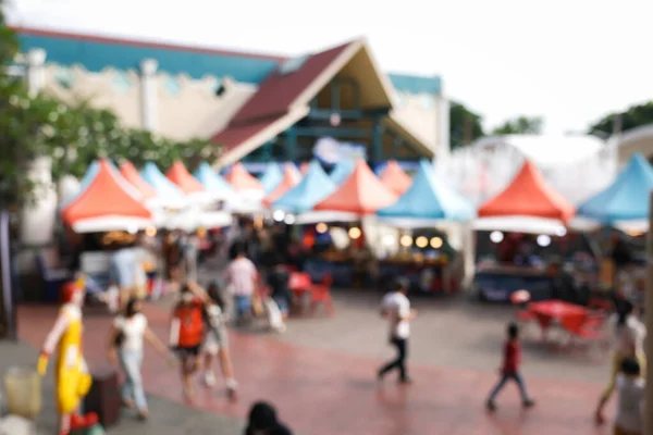 Blur image of flea market and food fair in Chiang mai city of Thailand. Also called festive food, street food. Marketplace consist of booth tent, shop, vendor and food stall. Busy with people.