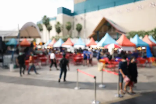 Blur image of flea market and food fair in Chiang mai city of Thailand. Also called festive food, street food. Marketplace consist of booth tent, shop, vendor and food stall. Busy with people.
