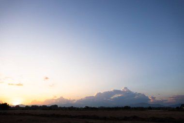 Gökyüzü çok güzel ve bulutlu. Manzara uzay, doğanın ışığı, gün batımı, gün doğumu, ufuk çizgisi veya ufuk çizgisi içerir. Sonbaharda arka plan ve duvar kağıtları için sarı, turuncu ve mavi renkte..