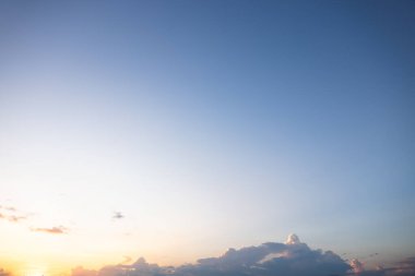 Gökyüzü çok güzel ve bulutlu. Uzay, doğanın ışığı, gün batımı, gün doğumu dahil. Sahne, arkaplan, zemin ve duvar kağıdı için sonbaharda akşam vakti sarı, turuncu ve mavi renkli.