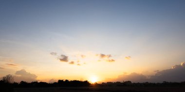 Gökyüzü çok güzel ve bulutlu. Manzara uzay, doğanın ışığı, gün batımı, gün doğumu, ufuk çizgisi veya ufuk çizgisi içerir. Sonbaharda arka plan ve duvar kağıtları için sarı, turuncu ve mavi renkte..
