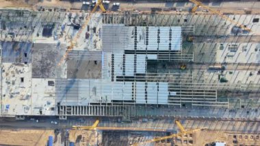 Havadan ya da üstten bakıldığında inşaat alanı inşaat çalışmaları, inşaat, inşaat işçilerinin beton yapısı, kule vinci ve ekipmandan oluşuyor. Mühendislik teknolojisiyle şehir geliştirme projesi.