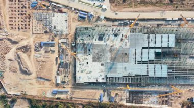 Havadan ya da üstten bakıldığında inşaat alanı inşaat çalışmaları, inşaat, inşaat işçilerinin beton yapısı, kule vinci ve ekipmandan oluşuyor. Mühendislik teknolojisiyle şehir geliştirme projesi.
