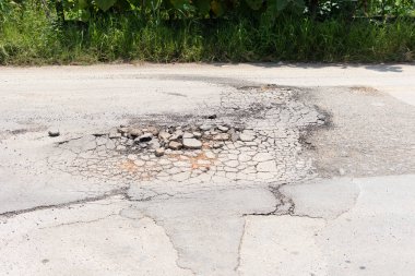 Asfalt yol yüzeyinde hasar var. Çukur, çakıl ve asfalt gibi çatlakları tıkayın. Araçlar, ulaşım ve trafik için tehlikeli. Tamir, bakım, yenileme ya da yeniden yapılandırma gerekiyor..