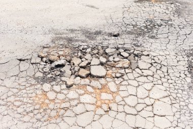 Asfalt yol yüzeyinde hasar var. Kırık çatlağa çakıl ve asfalt malzeme. Araçlar, ulaşım ve trafik için tehlikeli. Tamir, bakım, yenileme ya da yeniden yapılandırma gerekiyor..