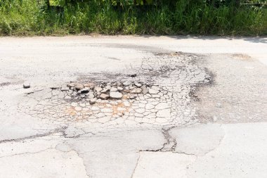Asfalt yol yüzeyinde hasar var. Çukur, çakıl ve asfalt gibi çatlakları tıkayın. Araçlar, ulaşım ve trafik için tehlikeli. Tamir, bakım, yenileme ya da yeniden yapılandırma gerekiyor..