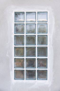 İnşaat halindeki beton duvarda şeffaf cam bloklu dış bina. Sınırdaki cam bloğun kenarına dolgu macunu sürmek için. Işık için inşaat malzemesi içeri girer..