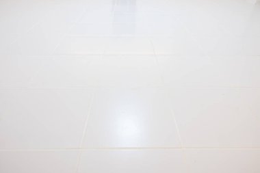 Akşamları, kare desenli beyaz fayans döşemesi perspektifli. Ilık beyaz ışıkla yansıma. Seramik yüzey pırıl pırıl. Arka plan için modern iç dekorasyon giysisi.