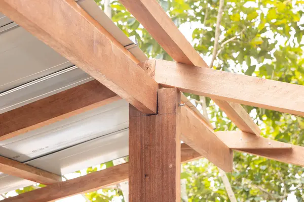 İnşaat halindeki çatı katındaki ahşap bağlantı yeri King post, ridge, kiriş, purlin ve metal levhadan oluşuyor. Ahşap işçilikli ev inşaatı.