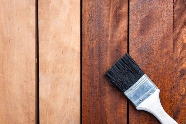 Kapalı boya fırçası kereste ya da ahşap ürünlere vernik uygula. Boyadan sonra daha koyu kahverengi görünmeden önce konsept arka plan için koruyucu veya kaplama leke yüzey giysisi.