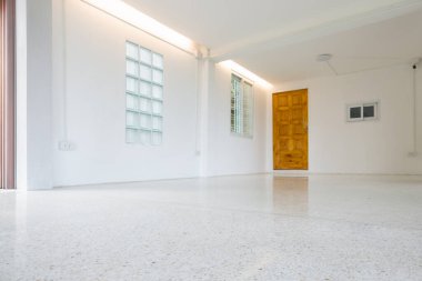 Yeni, temiz terrazzo zeminli Rom iç mimarisi. Zemine odaklan. İç dizayn, tavanda çizgili gizli ışık, temiz cam blok duvar ve ahşap kapı. Arkaplan için beyaz parlak renk tonu takımı.