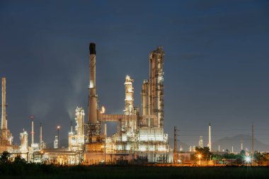 Petrol gazı rafinerisi ya da gece petrokimya fabrikası. Fiyat ve piyasa konsepti için gökyüzü giysisindeki boş fotokopi alanı. Petrol veya akaryakıt üretimi için birçok makine ekipmanı ve boru hattı işlenecek.