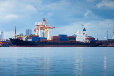 Gantry vinci ya da vinç iskelesi alacakaranlıkta büyük bir kargo gemisinde kargo konteynırıyla çalışıyor. Jaopraya nehrinin yanında, Tayland 'ın Bangkok' unda. Ulaşım, küresel ticaret ve ihracat kavramı.