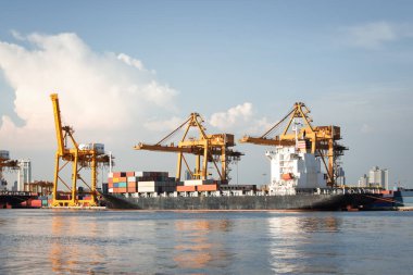 Büyük bir vinç ve kargo gemisi kargo konteynırı ve Tayland 'ın Bangkok limanına yanaşmış. Ticari taşımacılık, lojistik, uluslararası küresel ticaret, nakliye, ithalat sanayii.