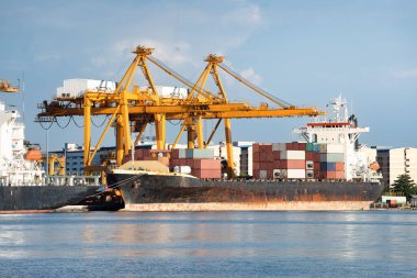 Büyük bir vinç ve kargo gemisi kargo konteynırı ve Tayland 'ın Bangkok limanına yanaşmış. Ticari taşımacılık, lojistik, uluslararası küresel ticaret, nakliye, ithalat sanayii.