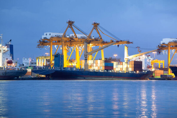 Large crane and cargo ship transport cargo container and docked at port in Bangkok of Thailand. Business industry of shipping, logistics, international global trade, freight transport, import export.