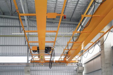 Fabrikada ya da depo binasında vinç var. Endüstriyel makine ya da kaldıraç, kanca ve tel ile kaldırma ekipmanları depolama, üretim ve üretim işlemleri için kiriş yapısı üzerinde hareket.