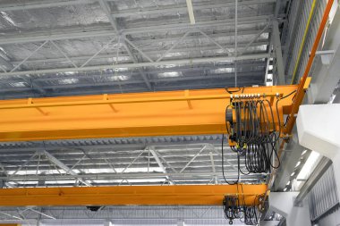 Fabrikada ya da depo binasında vinç var. Endüstriyel makine ya da kaldıraç, kanca ve tel ile kaldırma ekipmanları depolama, üretim ve üretim işlemleri için kiriş yapısı üzerinde hareket.