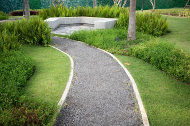 Bahçede yürüyüş ve manzara, park. Ayrıca patika, patika, patika ya da asfalt zemin de denir. Beton bank, doğal bitki, çalı, çimen ve çimenler dahil. Açık hava peyzaj dekorasyonu.