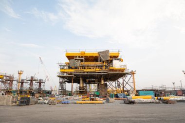 Kıyıda inşaat halindeki petrol kulesi. Çelik yapı platformunu kaldırmak için, teknoloji mühendisliği. Ham petrol kaynakları ve doğal gaz arama ve sondaj için ağır sanayi.