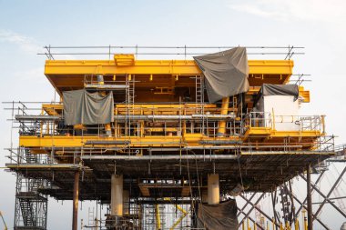 Kıyıda inşaat halindeki petrol kulesi. Çelik yapı platformunu kaldırmak için, teknoloji mühendisliği. Ham petrol kaynakları ve doğal gaz arama ve sondaj için ağır sanayi.