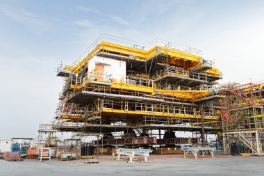 Sürüngen vinç tarafından kıyıda petrol kuyusu inşaatı. Enerji yakıtları yatırımlarında ham petrol arama ve sondajı için ağır sanayi ve mühendislik teknolojisi.