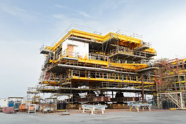 Sürüngen vinç tarafından kıyıda petrol kuyusu inşaatı. Enerji yakıtları yatırımlarında ham petrol arama ve sondajı için ağır sanayi ve mühendislik teknolojisi.