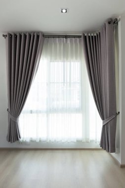 İnce ve kalın perdeler, güneş ışığını filtrelemek için cam pencerelerle perdelerde asılı, doğal ışık, lamine zemini yansıtıyor. İç tasarım kavramı, modern mimari ve arkaplan.