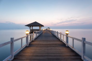 Güzel bir pavyon ve boş gökyüzü ve sakin bir deniz ile ahşap köprü Chonburi, Tayland 'da seyahat cazibesine sahip. Manzaralı kıyı manzarası doğal güzelliği mimari mühendislikle birleştirir..