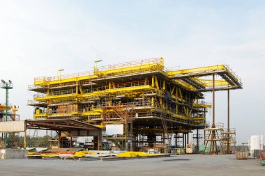 Offshore platformu yapım aşamasında. Büyük enerji endüstrisini gösteren teknoloji mühendisliğine sahip sarı çelik yapı iskeleti. Doğal gaz ve ham petrol çıkarmak için sondaj projesi.