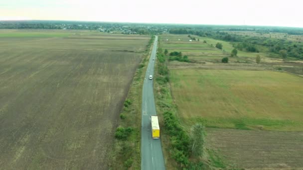 Ciężarówka Jedzie Wiejską Drogą Czerwony Samochód Ciężarowy Przyczepą Niebiesko Żółtą — Wideo stockowe