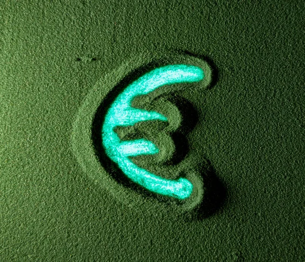 Hand drawing the Euro currency symbol in the Green Sand. Male hand writes the Euro currency symbol on the green sand with blue backlight. Top view 4k resolution
