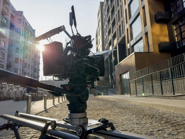 movie camera on the slider in the backlight from the sub, the rays of the sun. shooting outdoors in an urban location