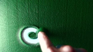 Yeşil Kum 'daki Leo burç sembolünü elle çizmek. Erkek el, yeşil kumun üzerine beyaz arka ışıklandırmalı Leo burcunun sembolünü yazar. Üst görünüm 4k çözünürlüğü