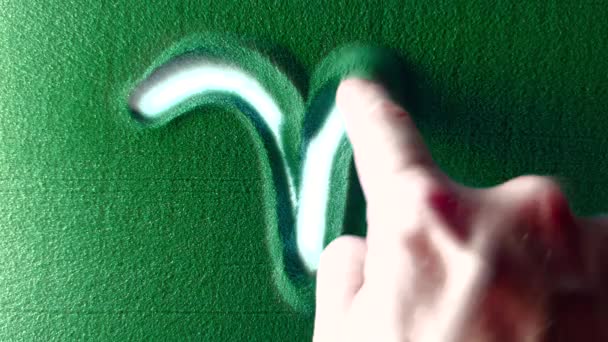 손으로 샌드에 양자리 기호를 그렸습니다 백라이트가 양자리 기호를 위에서 해상도 — 비디오