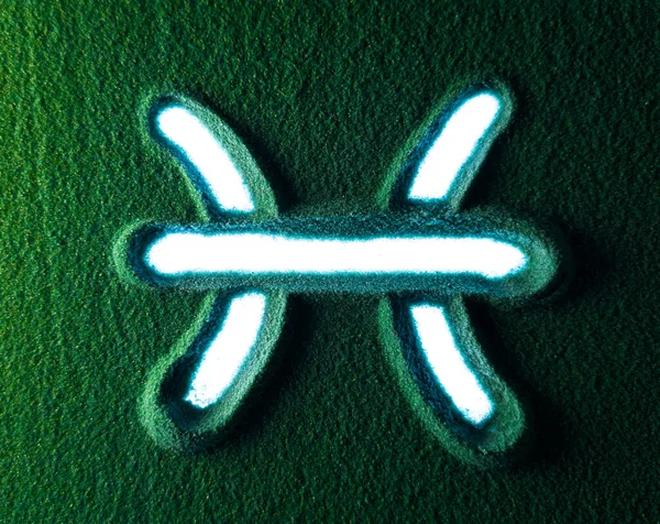 緑の砂の中にピセスのサイン記号を描く手 男性の手は白いバックライトが付いている緑の砂のピセスのホロスコープ記号記号を書く トップ表示4K解像度 — ストック写真