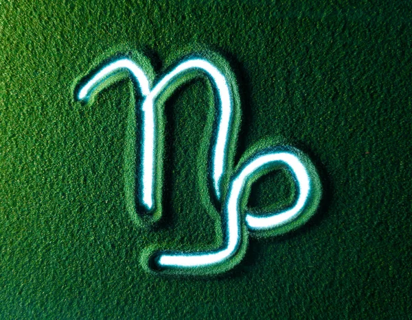 Ruční Kreslení Symbol Kozoroha Horoskopu Zeleném Písku Mužská Ruka Píše — Stock fotografie