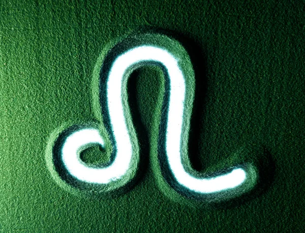 緑の砂の中にレオのサイン記号を描く手 男性の手は白いバックライトが付いている緑の砂のレオのホロスコープ記号記号を書く トップ表示4K解像度 — ストック写真