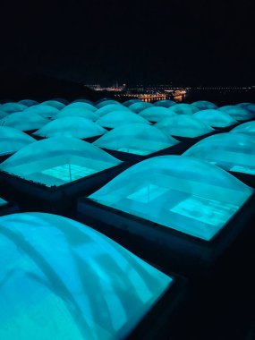 Lambalardan perspektif, küresel pencerelerden mavi ışık. Müzenin çatısında gece şehrinin arka planında mavi renkli parlak pencereler vardı. cimena 'nın yeri. Kyiv