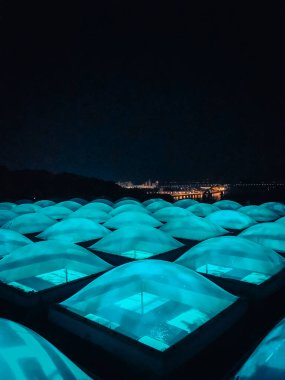 Lambalardan perspektif, küresel pencerelerden mavi ışık. Müzenin çatısında gece şehrinin arka planında mavi renkli parlak pencereler vardı. cimena 'nın yeri. Kyiv