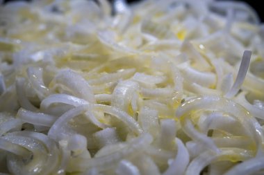 Yağ ve doğranmış soğan tavada. Soğanlar, bol yağlı ve siyah bir tavada kızartılır. Yemek pişirme ve mutfak konsepti. Seçici Odaklanma Arayüzü