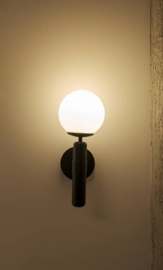 Süslü bir parantez ile duvara tutturulmuş bir ışık tutacağı. Seçici Odaklanma Işıklandırma aksesuarı