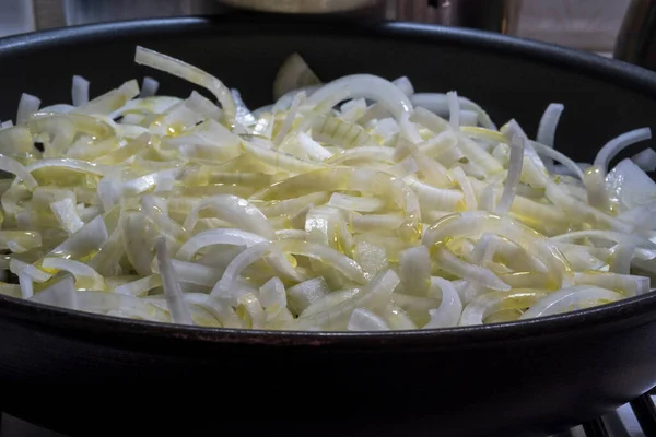 锅里的油和切碎的洋葱洋葱是用大量的油在一个黑色的锅 烹调和厨房概念油炸的 选择性焦点阵线 — 图库照片