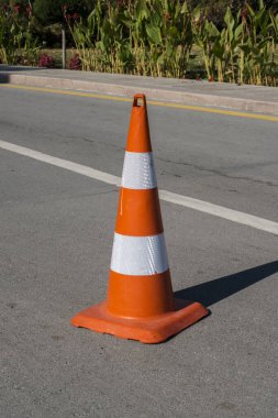 Orange traffic cones in the middle of the street. road construction. Road cone bright orange traffic cones standing in a row on light gray asphalt