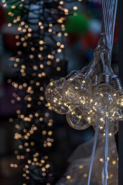 Colorful close up details of christmas fair market. Lighting Equipment decorations for sales. Selective Focus Ornament. Blur 