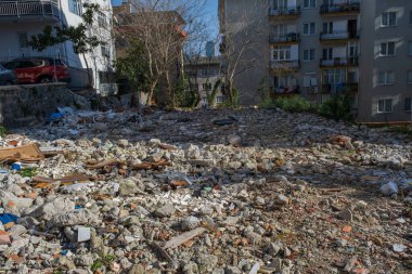 rubble pile leveled after a building was demolished by construction equipment in the neighborhood.