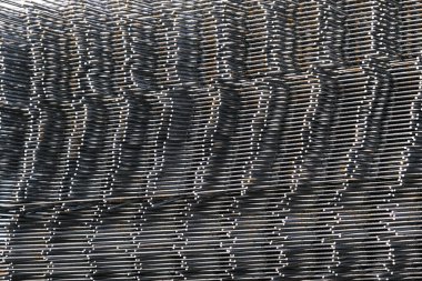 Bir yığın demir çubuk üst üste istiflenir. Birbiri üstüne istiflenmiş demir parmaklıklar, inşaatlarda ve endüstriyel soyutlamalarda kullanılır..