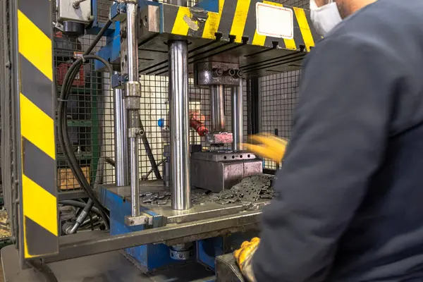 Otomasyon hidrolik baskı makinesi üretim hattı. Endüstriyel metal fabrikaları. Bir işçi hidrolik pres makinesinde ölüme baskı yapıyor..